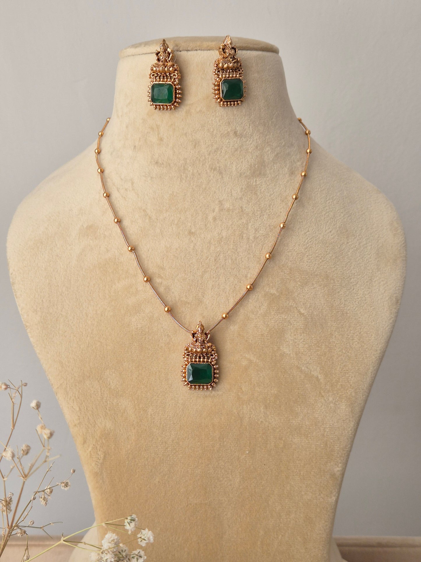 handcrafted gold-toned necklace set with vibrant green square stones and geometric accents by naitri.in