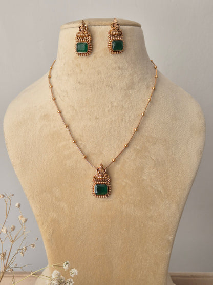 handcrafted gold-toned necklace set with vibrant green square stones and geometric accents by naitri.in