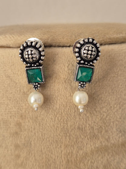 Handcrafted oxidized silver earrings with emerald green stones and dangling mini pearls by naitri.in