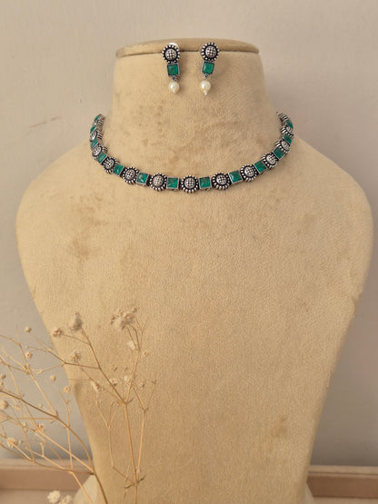 oxidized silver choker necklace set with green stone studs and pearl drop accents by naitri.in