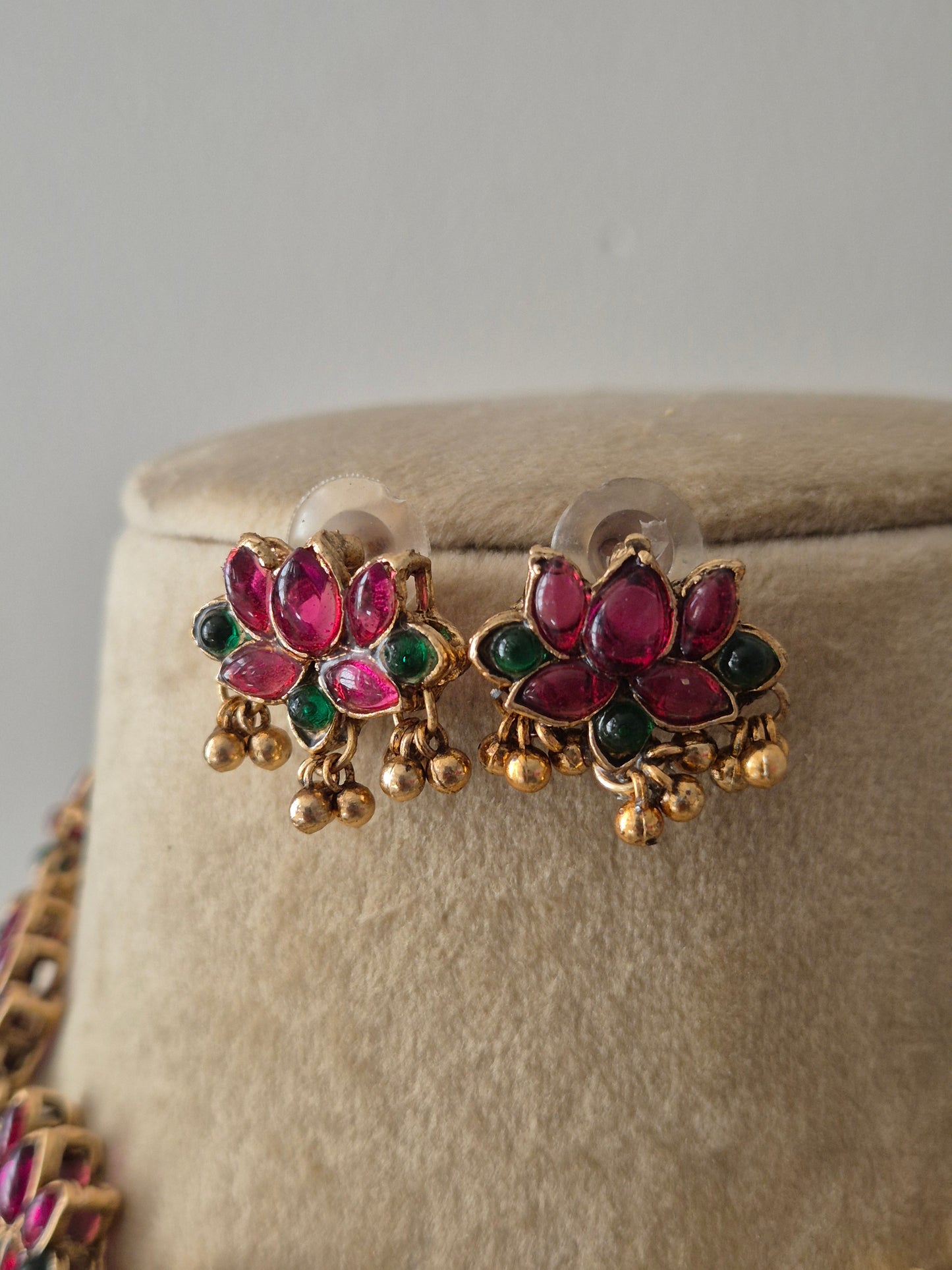 Gold-toned earrings with red-green lotus designs and golden bead accents by naitri.in