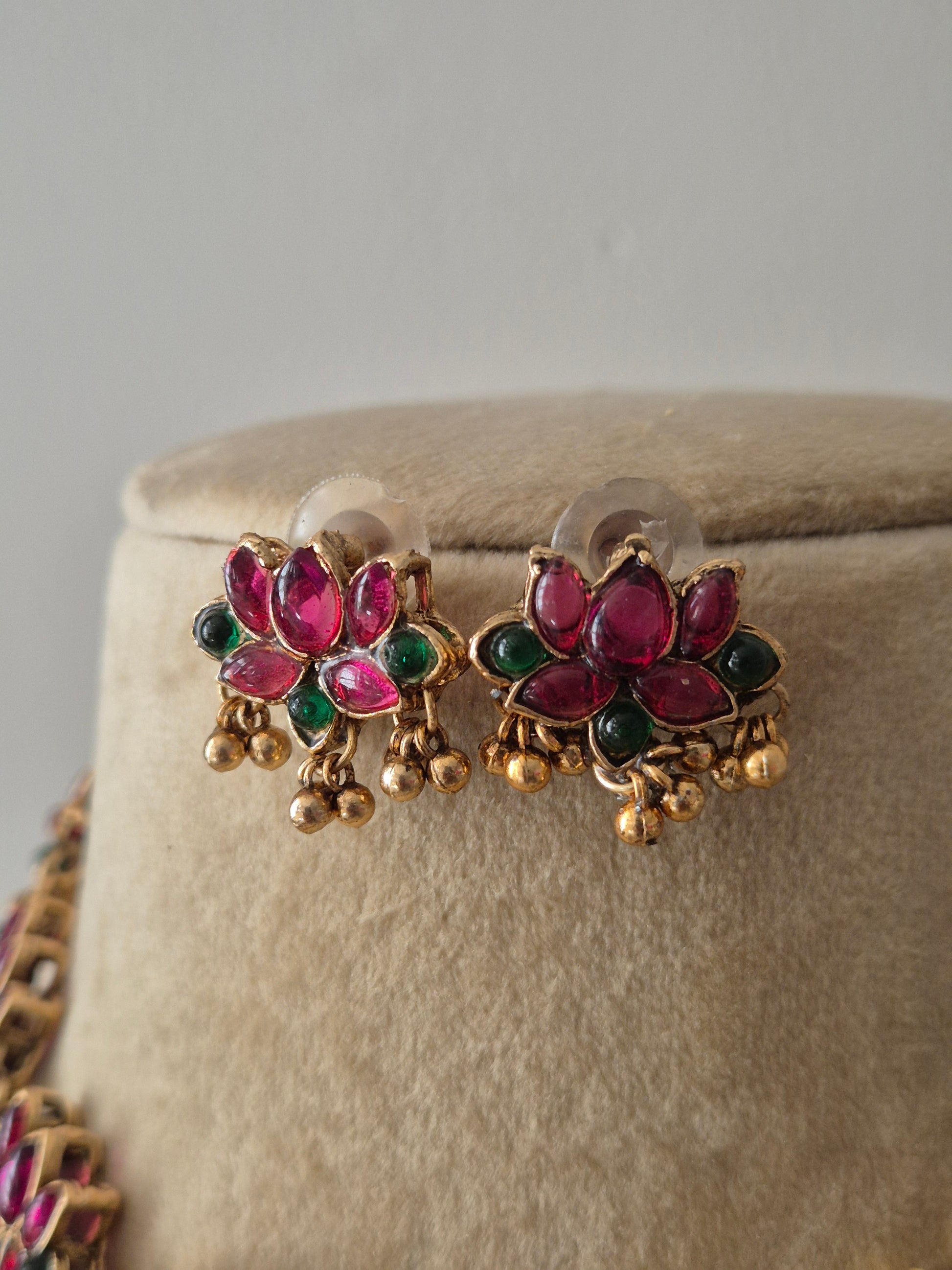 Gold-toned earrings with red-green lotus designs and golden bead accents by naitri.in