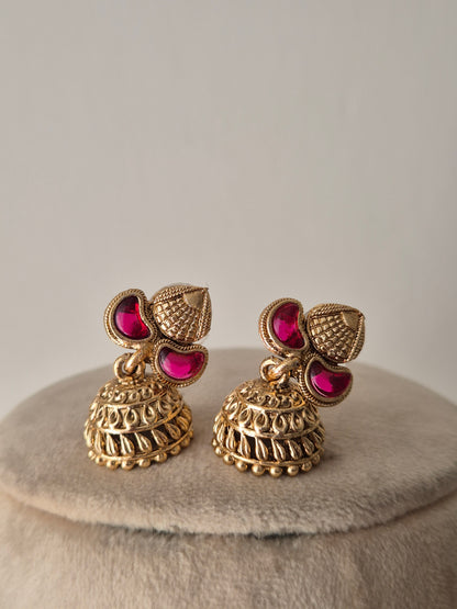 Antique gold earring set with ruby-colored stone accents by naitri.in