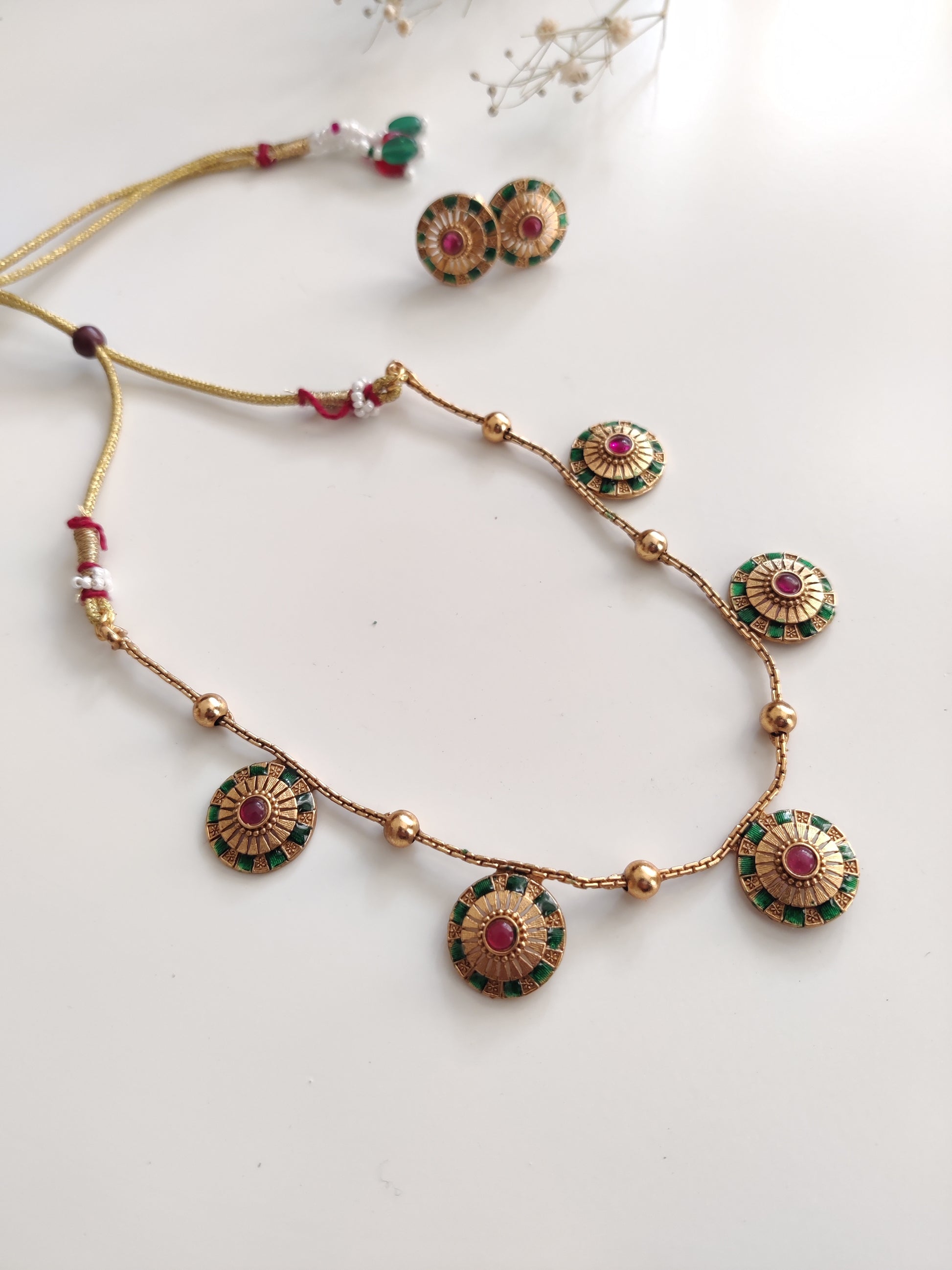 Close-up of ornate temple necklace set showcasing detailed metal craftsmanship with gold and silver tones