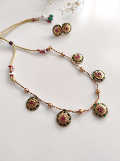 Close-up of ornate temple necklace set showcasing detailed metal craftsmanship with gold and silver tones