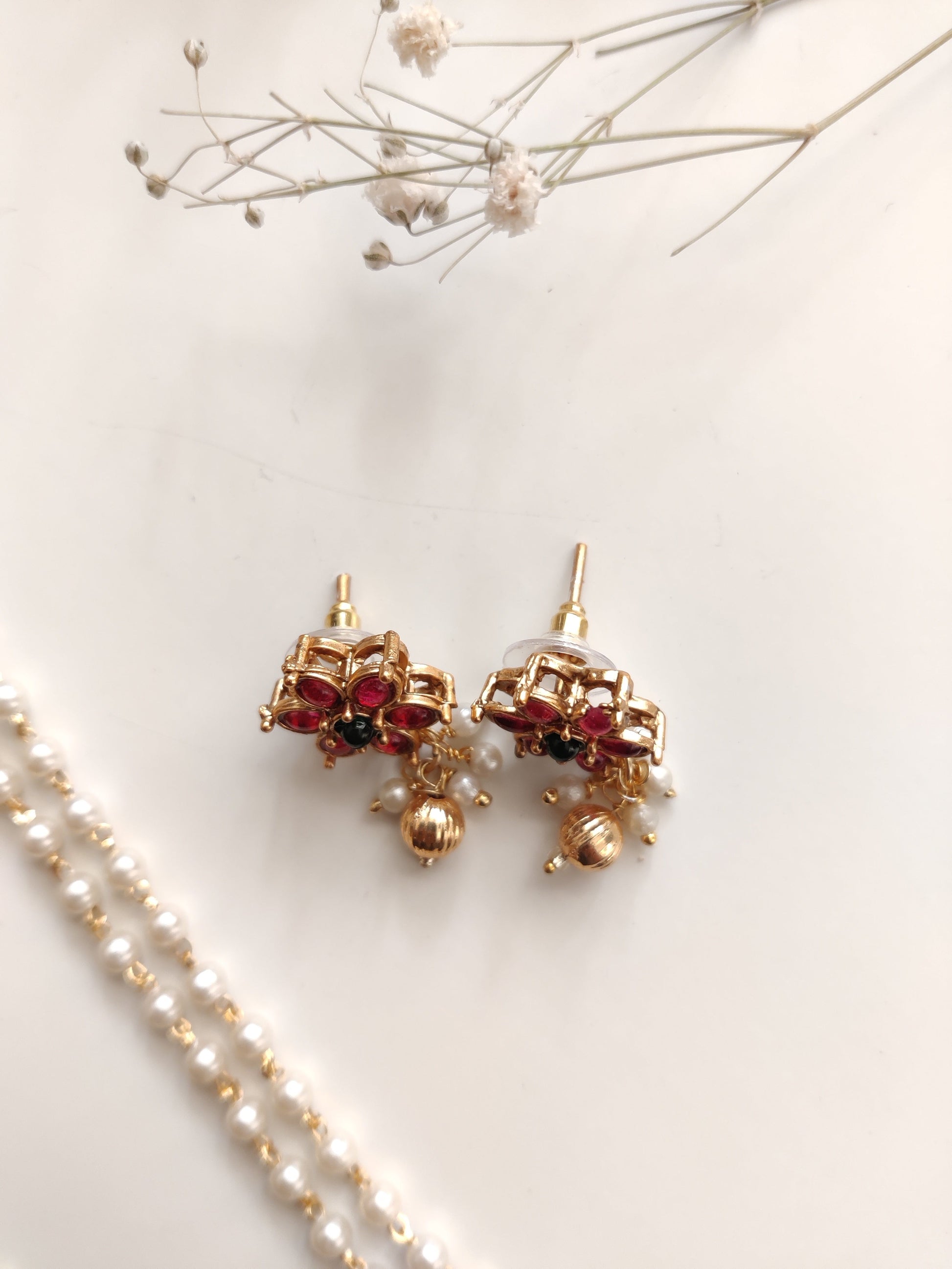 Artistic shot of temple necklace set featuring gold, green, and red embellishments and intricate metalwork