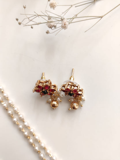 Artistic shot of temple necklace set featuring gold, green, and red embellishments and intricate metalwork