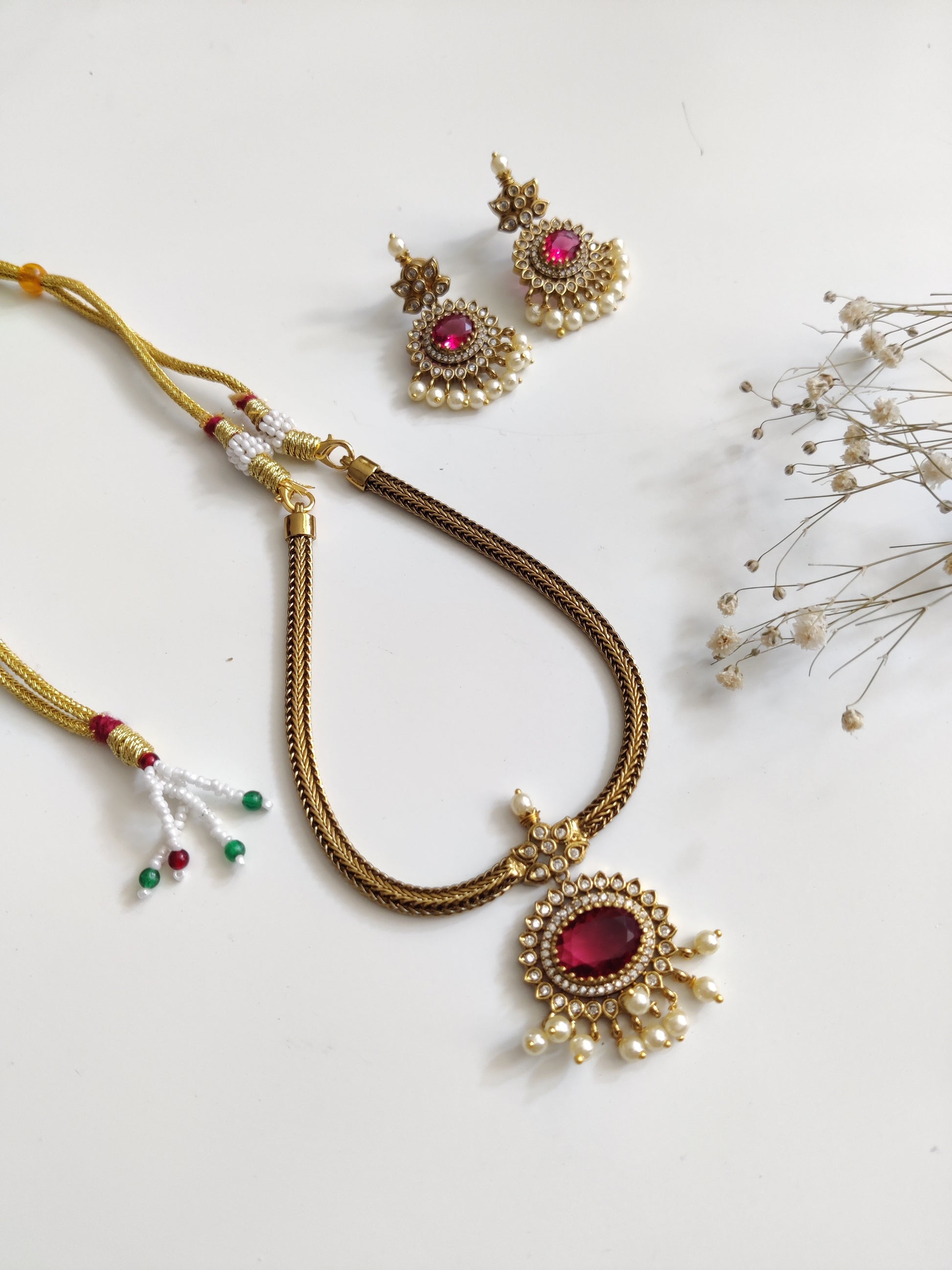 Premium temple necklace set featuring lush gold and red accents, photographed to showcase intricate design