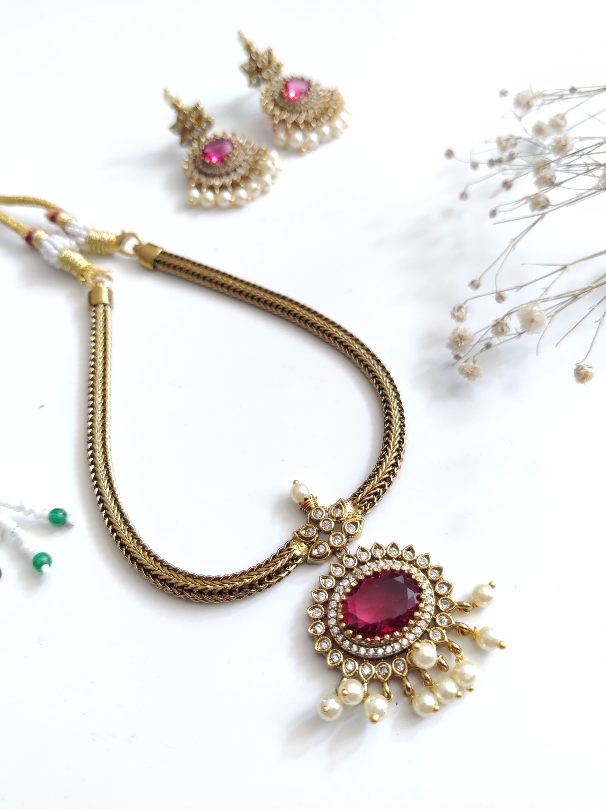 Premium temple necklace set featuring lush gold and red accents, photographed to showcase intricate design