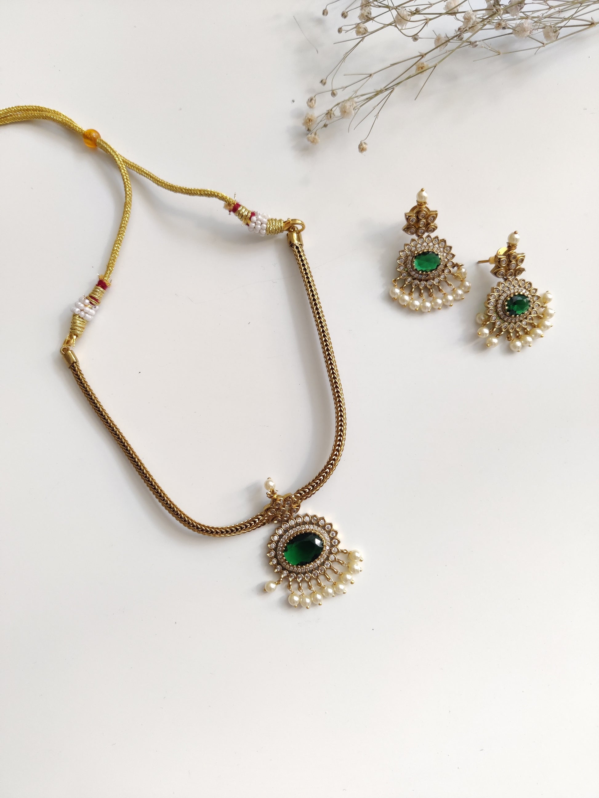 Elegant temple necklace with gold and green details, showcased with focus on delicate metalwork