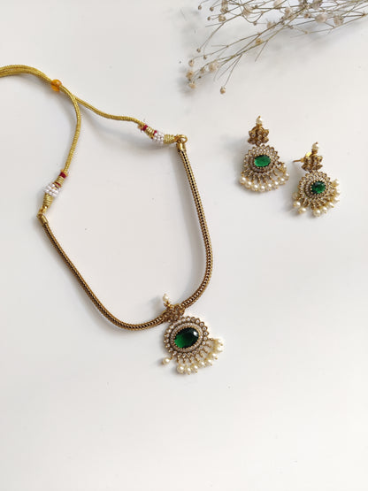 Elegant temple necklace with gold and green details, showcased with focus on delicate metalwork