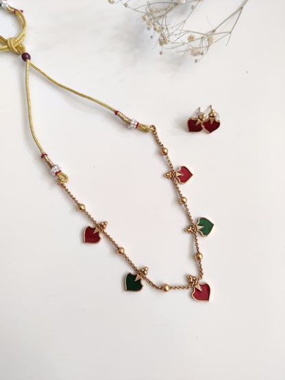 Luxurious temple necklace set with gold, red, and green highlights, draped to display fine artisan work