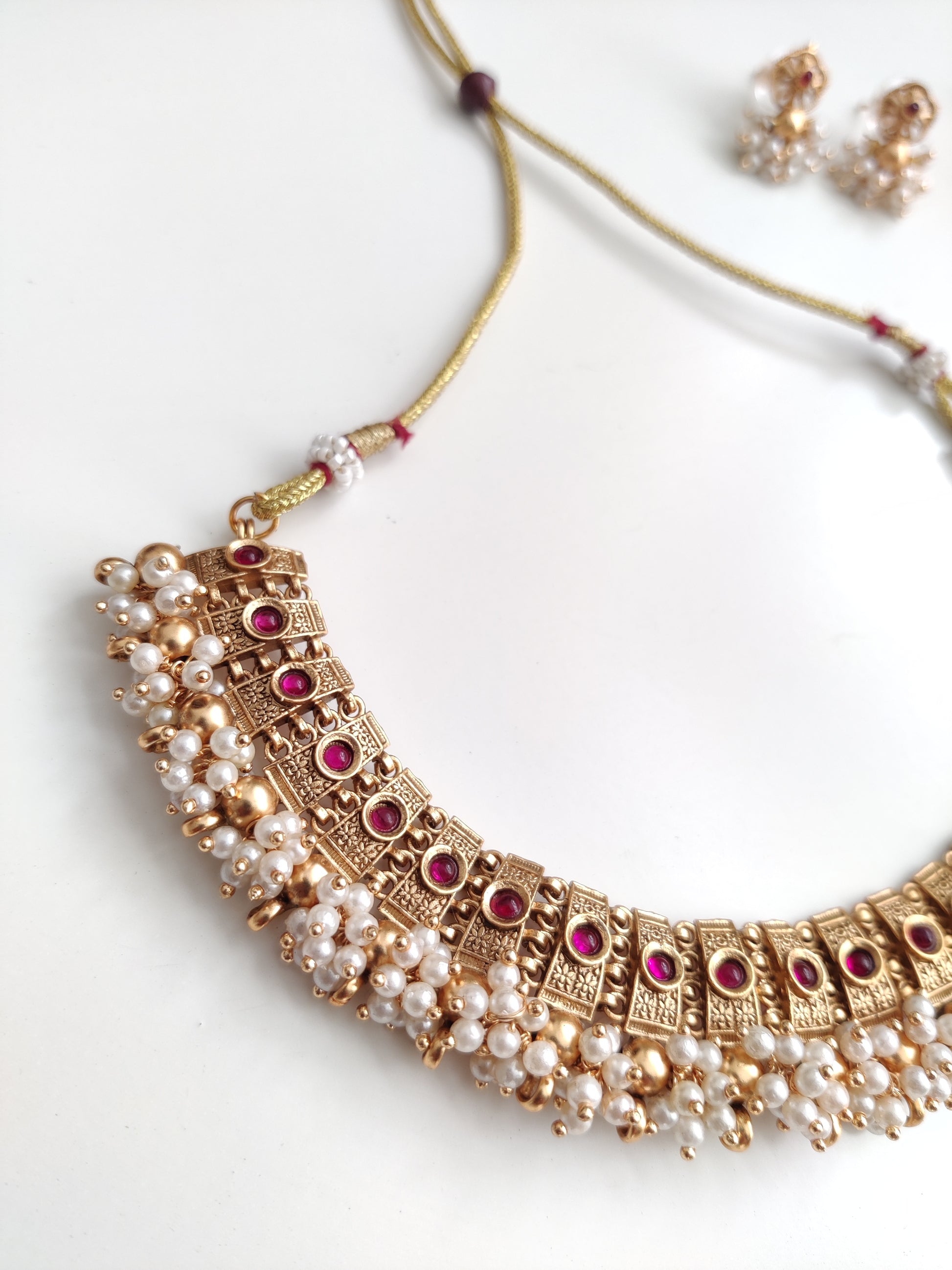 Elegant gold-tone temple necklace set in metal alloy shown to highlight refined craftsmanship