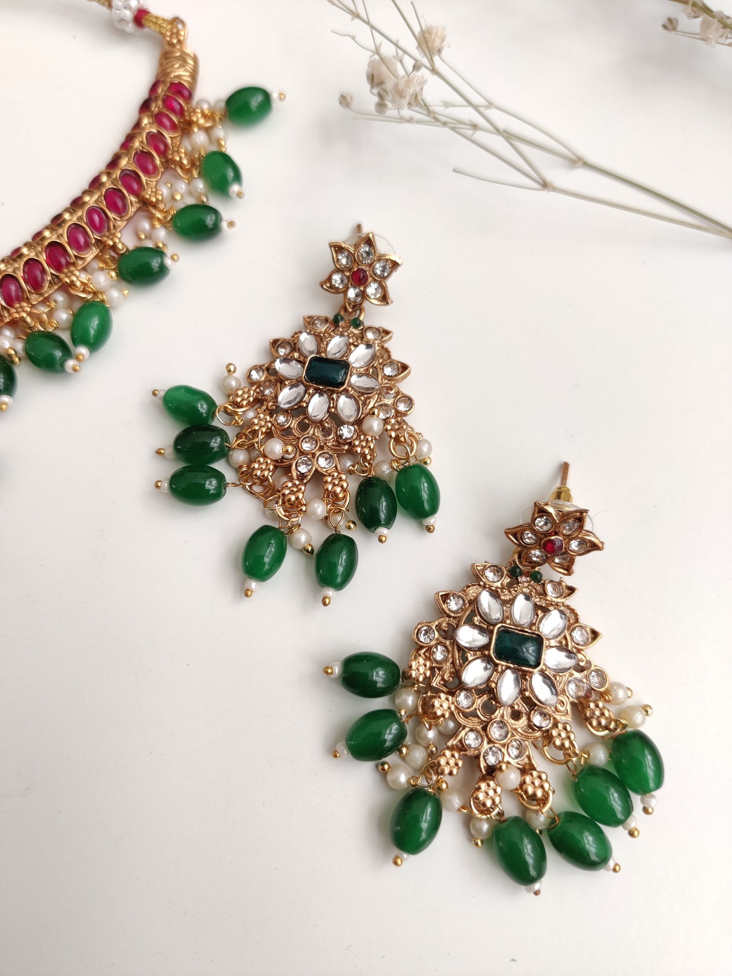 Premium temple necklace set with rich gold, green, and red details photographed on neutral background