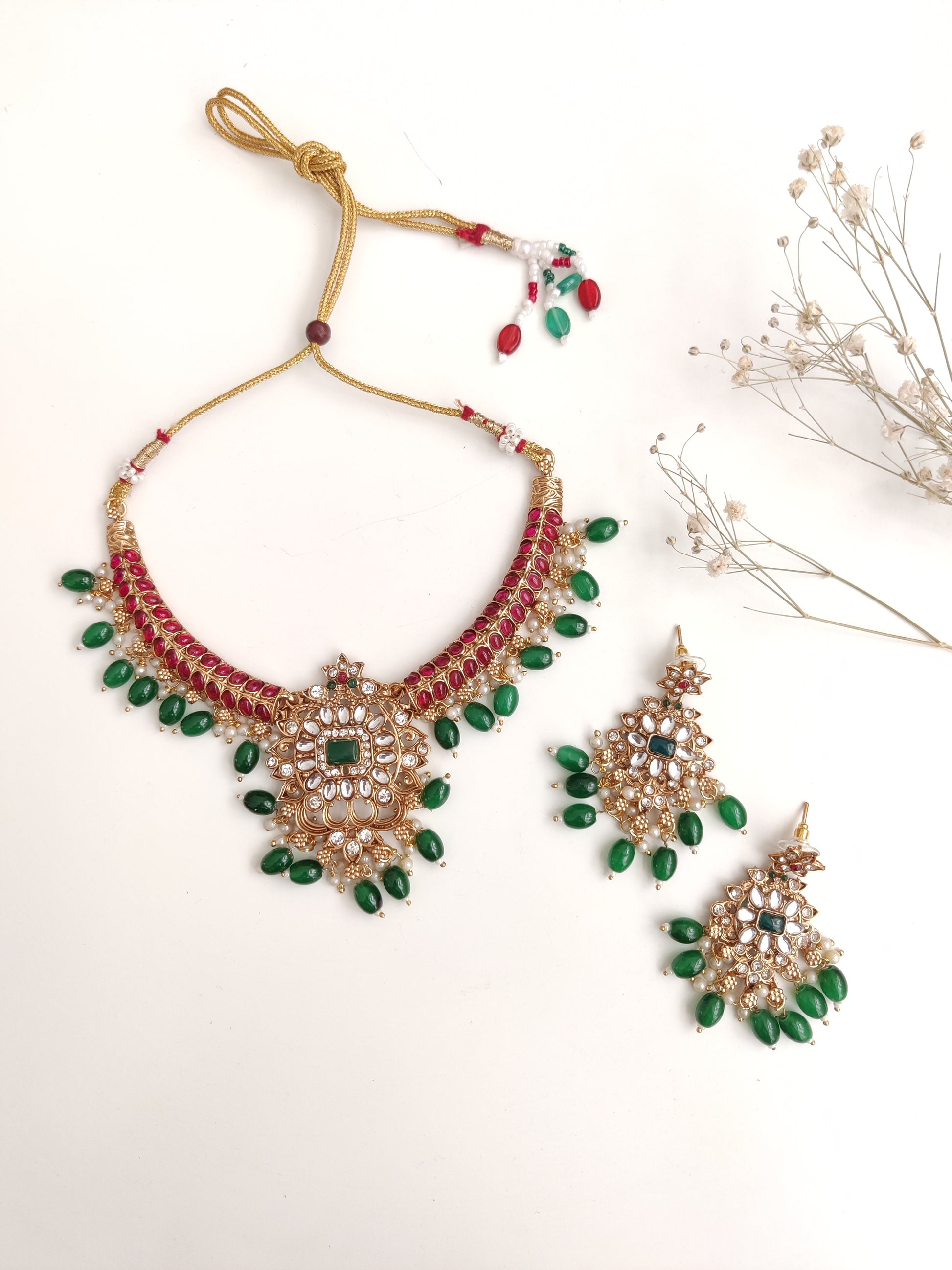 Premium temple necklace set with rich gold, green, and red details photographed on neutral background