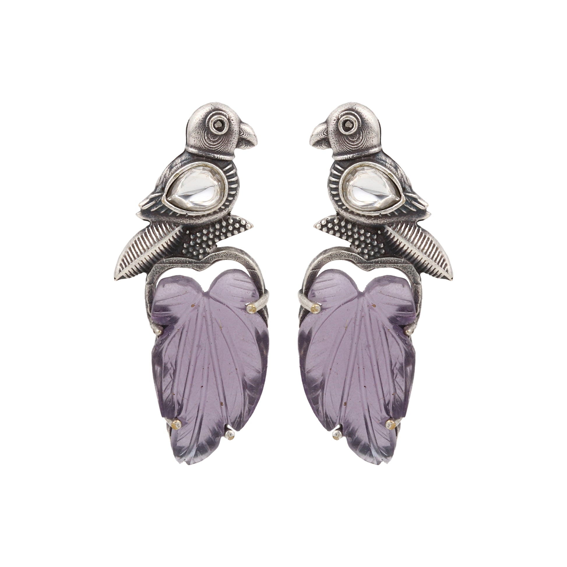 Purple stud earrings with stonework, displayed on a jewelry stand