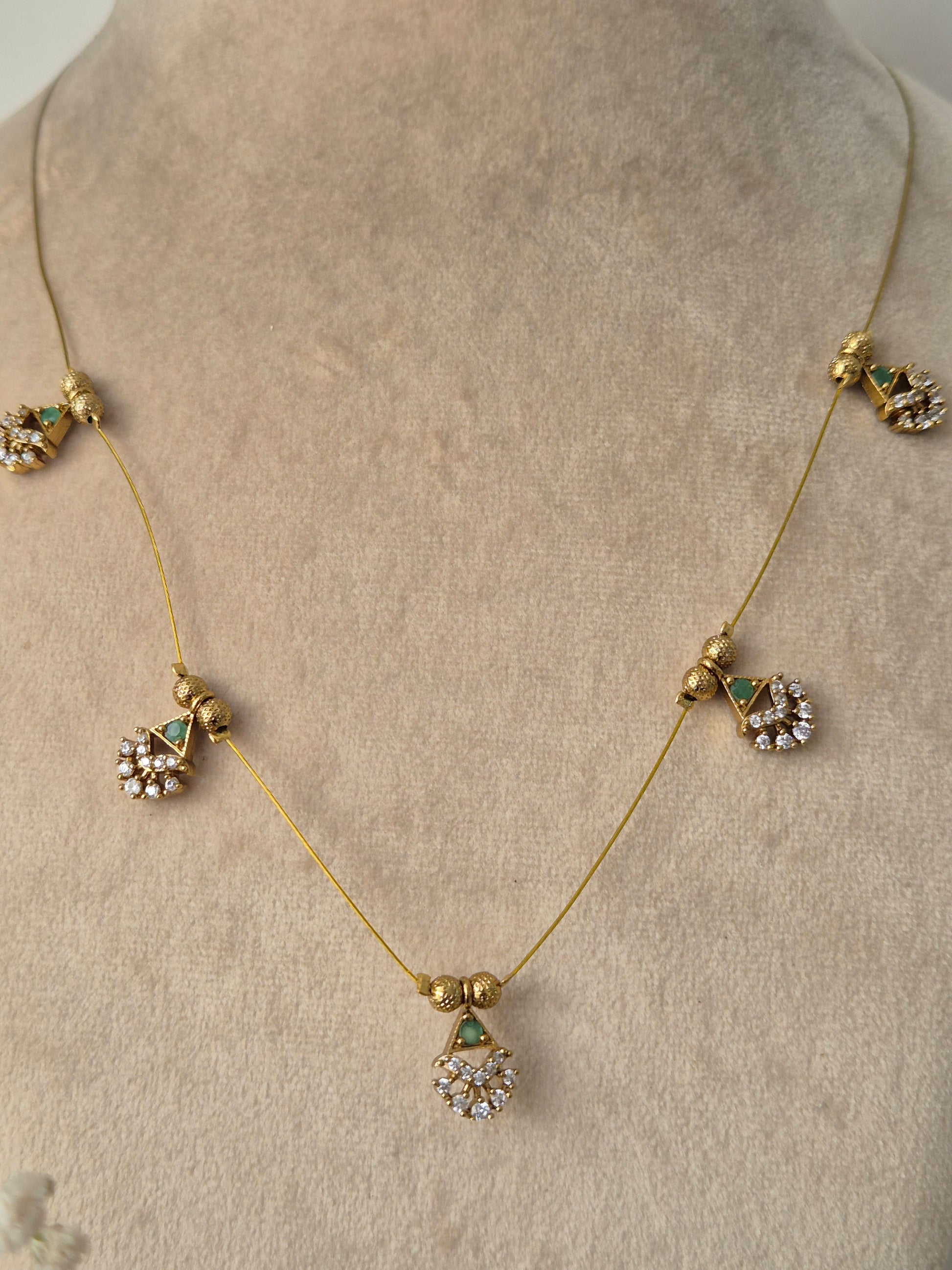 Decorative necklace set with green gemstones golden plated jewelery set minimal and antique design by naitri.in