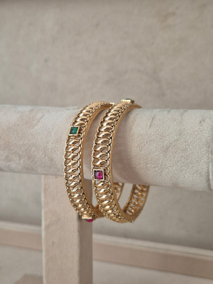 Two gold-plated chain-link bangles with small square green and pink gemstone accents, by naitri.in
