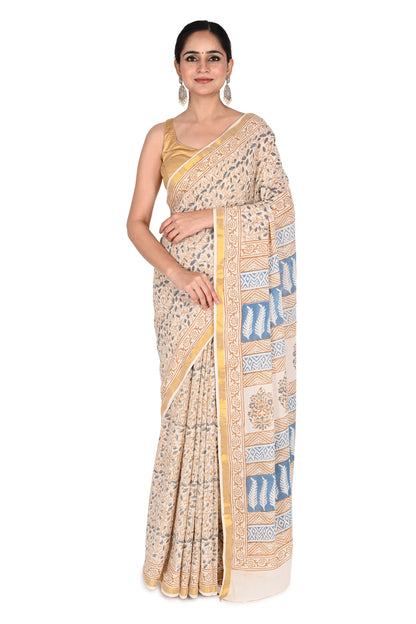 Woman wearing the Indrakshi hand block printed cotton saree in beige and white with blue floral and geometric motifs by naitri.in