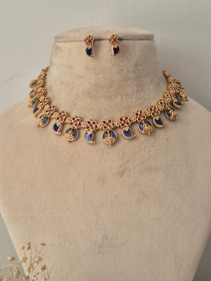 Gold-toned jewelry set, featuring a necklace with blue and pink enamel details and matching drop earrings by naitri.in