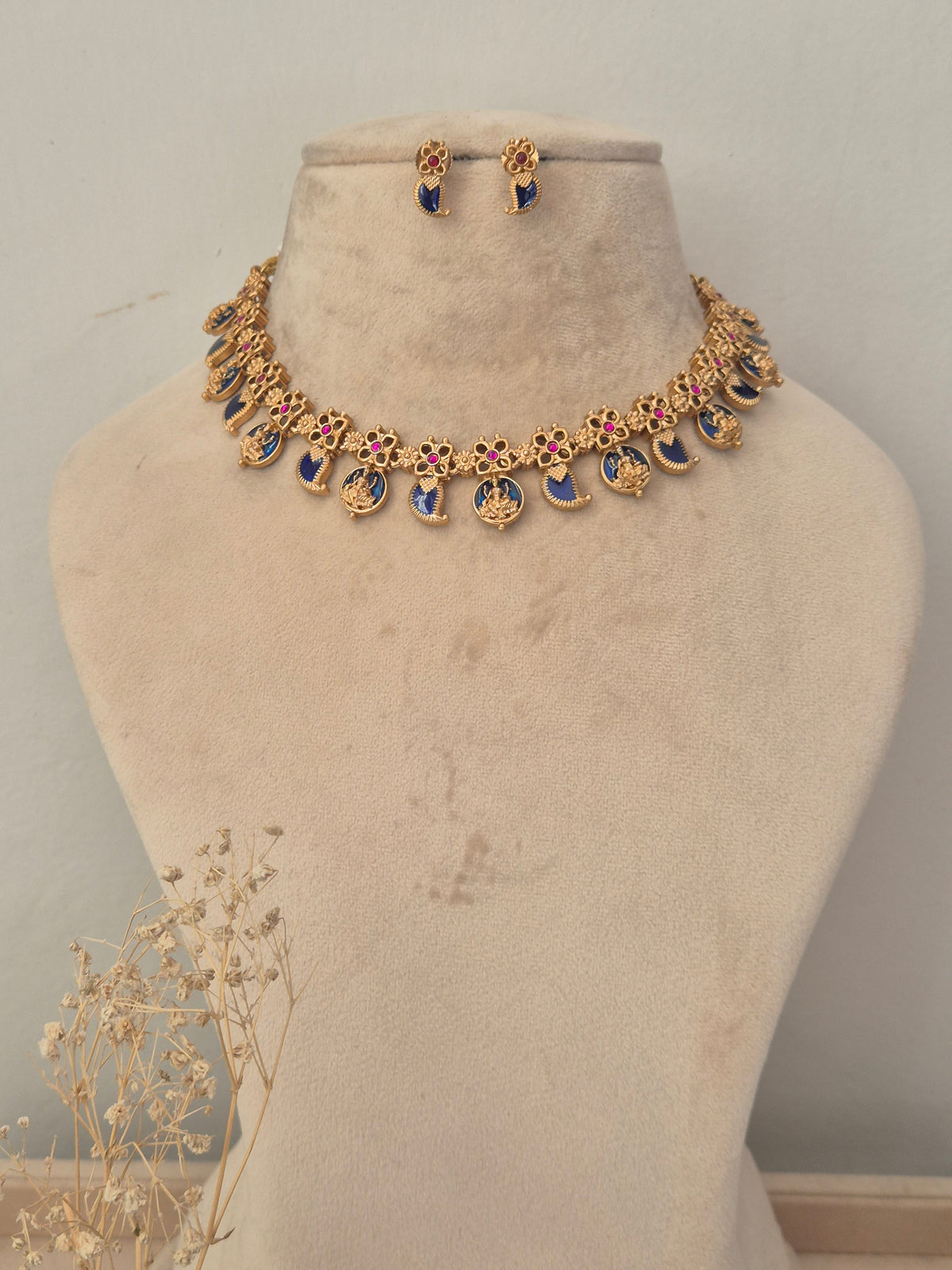 Gold-toned traditional necklace and matching earrings , decorated with blue enamel and pink stone accents, by naitri.in