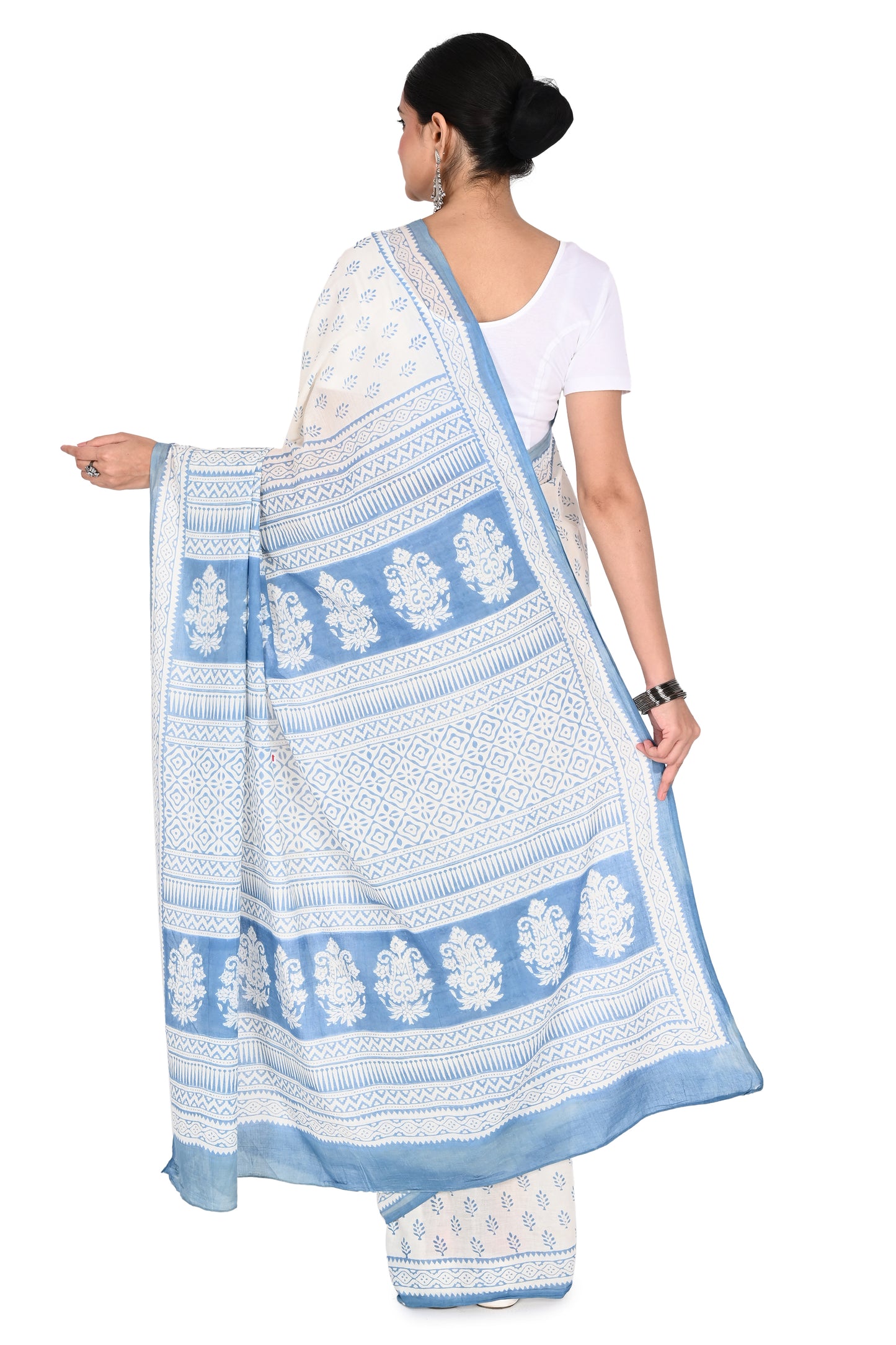 Model showcasing a classic drape of a white cotton saree with a blue floral border and printed blouse piece by naitri.in