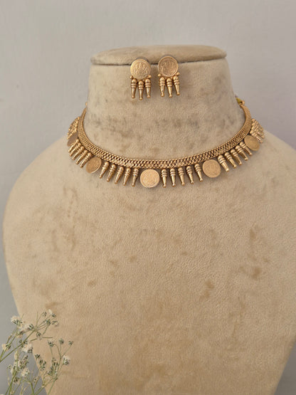 Gold coin-style necklace and matching drop earrings featuring a brass alloy golden ethnic choker and matching textured button earrings for festive wear by naitri.in