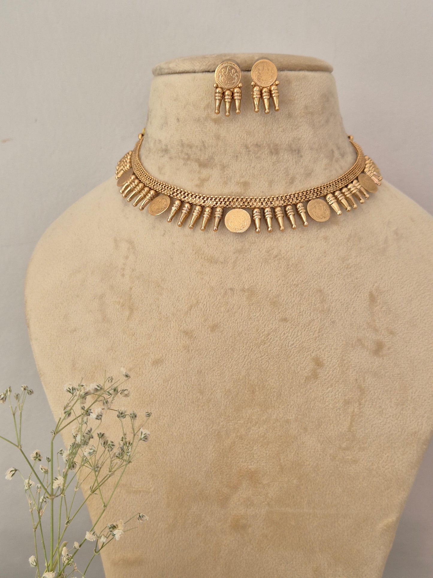 Gold-toned choker necklace and matching round button earrings set  the necklace features an intricate textured chain design adorned with alternating small vertical bar accents and flat circular gold-toned coins by naitri.in