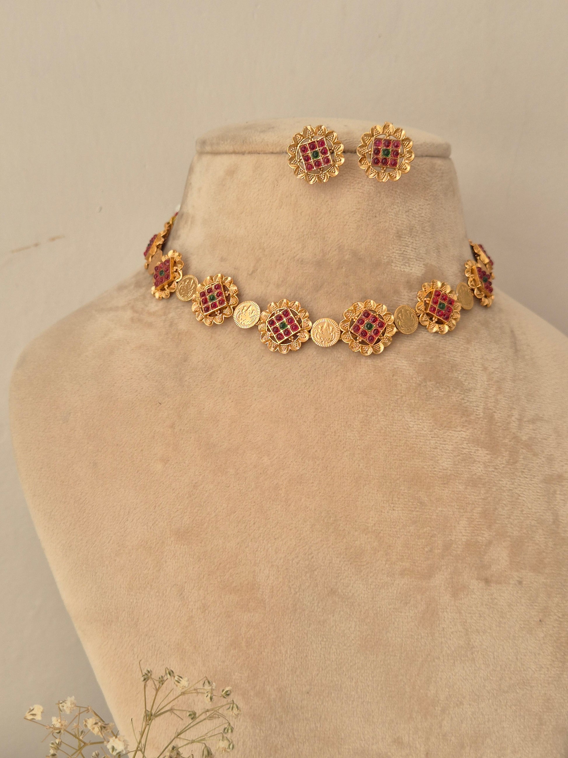 Festive gold-finish choker necklace set featuring circular floral motifs studded with red and green stones for wedding and ethnic wear by naitri.in