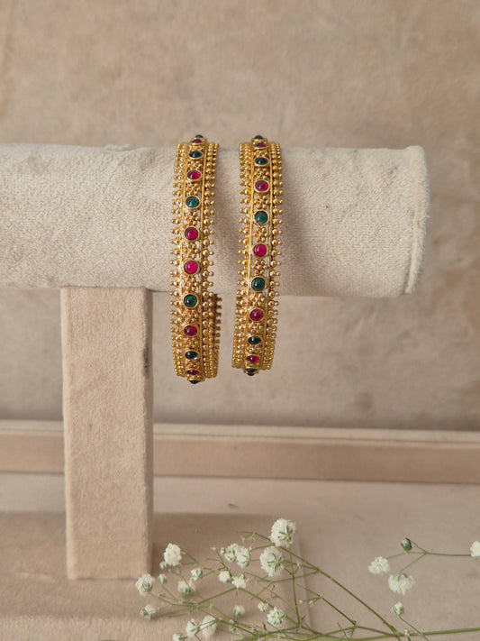 Set of 2 gold-toned bangles studded with vibrant red, green, gemstones, by naitri.in