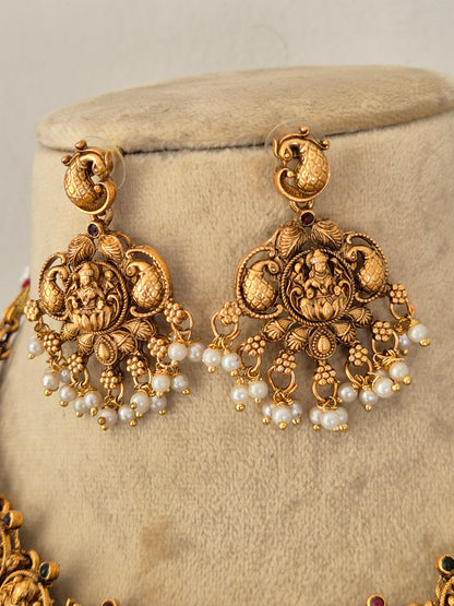 Gold-toned traditional Indian jhumka earrings with intricate filigree work, floral motifs, and clusters of white faux pearls, by naitri.in