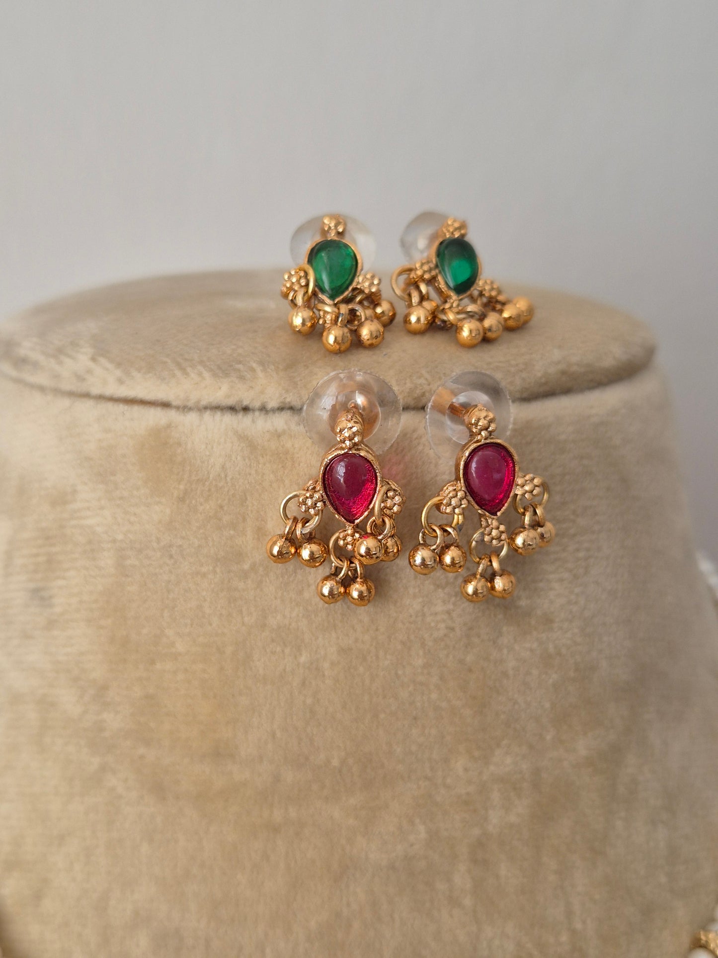 Gold-polished delicate studs with red-green  kemp stones embellishments