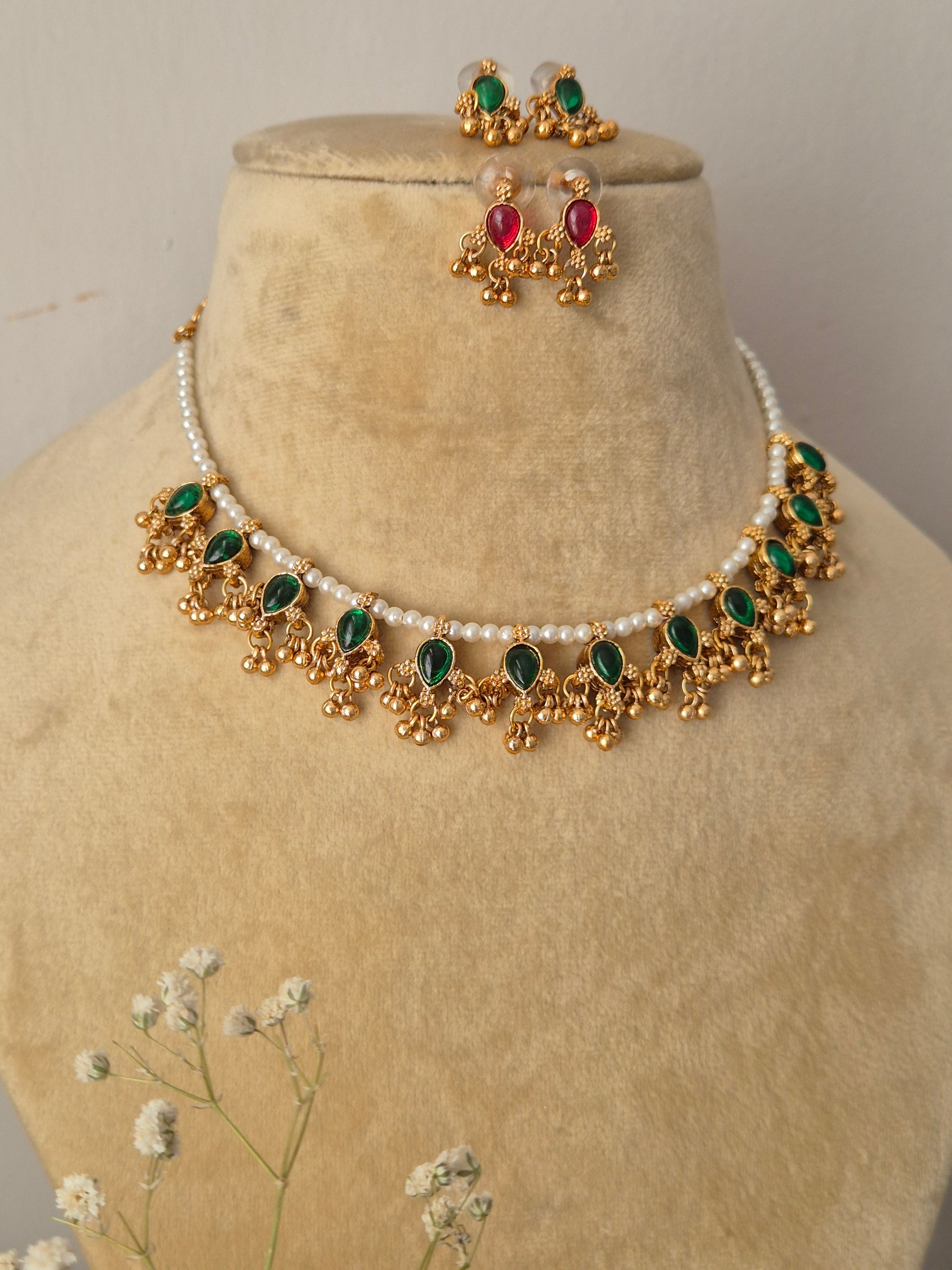 Gold-polished delicate pearl choker with green kemp stone embellishments and matching versatile stud earrings from the Golden Ethnic Jewellery line by naitri.in