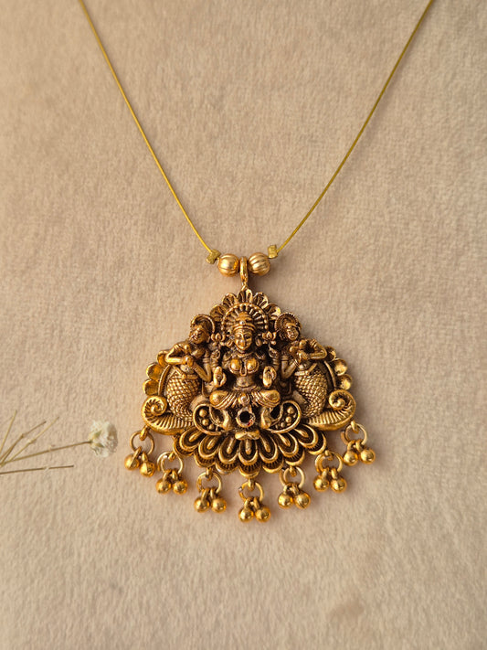 Gold-toned Jayalaxmi pendant featuring a detailed Goddess Laxmi motif with small metallic beads and a delicate gold chain by naitri.in
