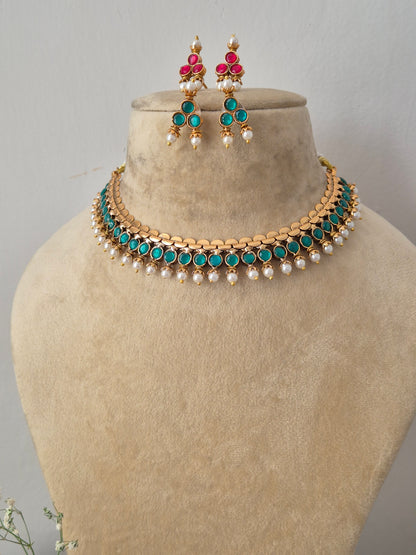 Handcrafted dual-sided statement gold choker set adorned with ruby-pink gemstones and tiny pearl drops by naitri.in