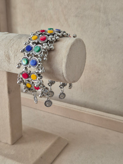Oxidized silver Jharna bangle with multi-colored circular enamel designs and dangling silver beads Elegant antique silver-toned tribal cuff bracelet with traditional festive details by naitri.in