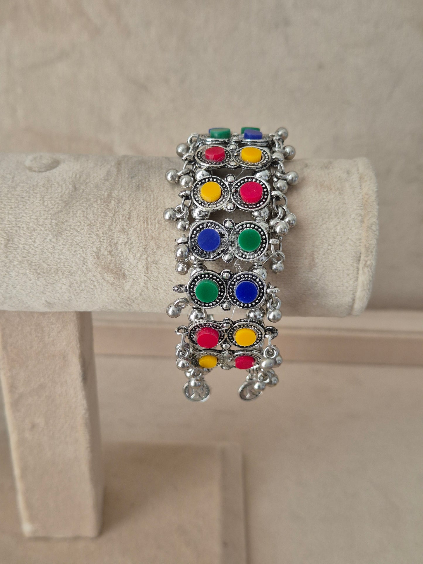 Statement silver-plated bohemian Kada bangle featuring an intricate mesh pattern inlaid with colorful round stones and hanging ghungroo clusters, by naitri.in