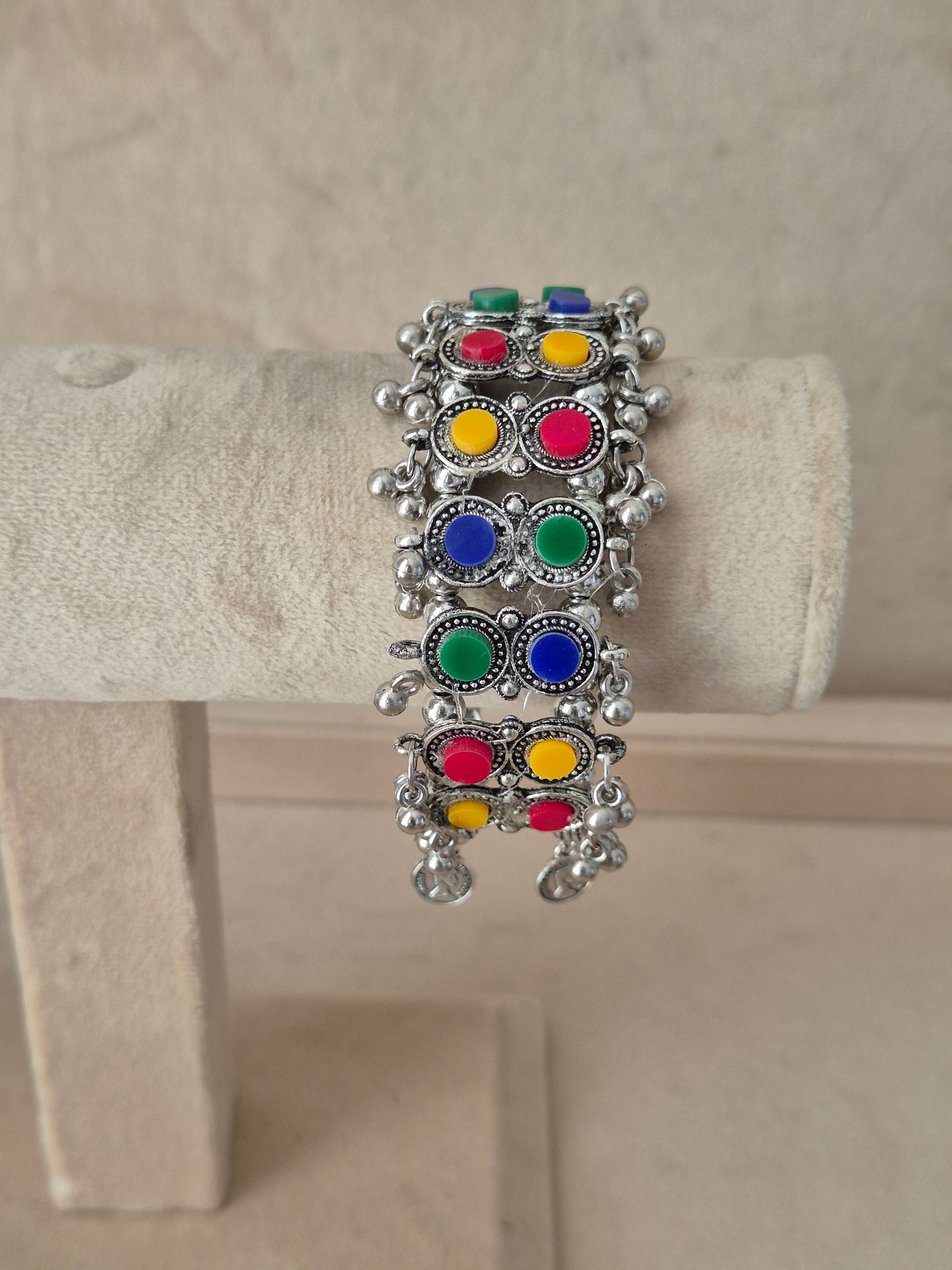 Statement silver-plated bohemian Kada bangle featuring an intricate mesh pattern inlaid with colorful round stones and hanging ghungroo clusters, by naitri.in