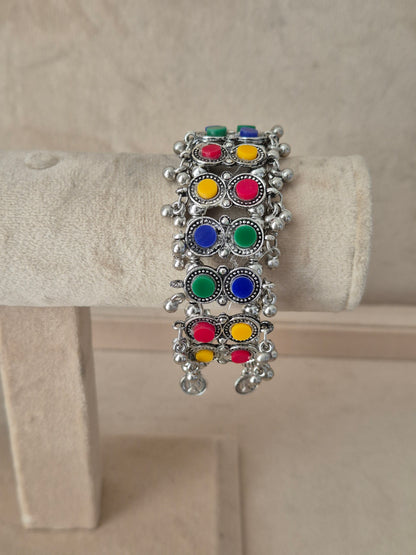 Statement silver-plated bohemian Kada bangle featuring an intricate mesh pattern inlaid with colorful round stones and hanging ghungroo clusters, by naitri.in