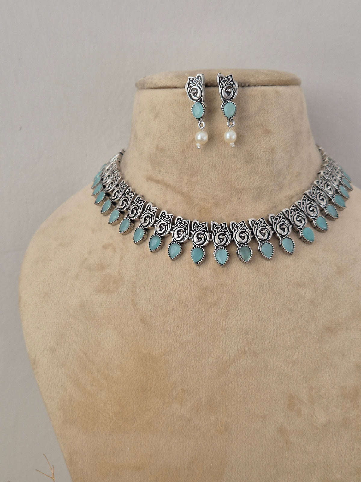 Boho-chic handcrafted silver-toned necklace set featuring vibrant turquoise embellishments and pearl drops for festive and ethnic wear by naitri.in