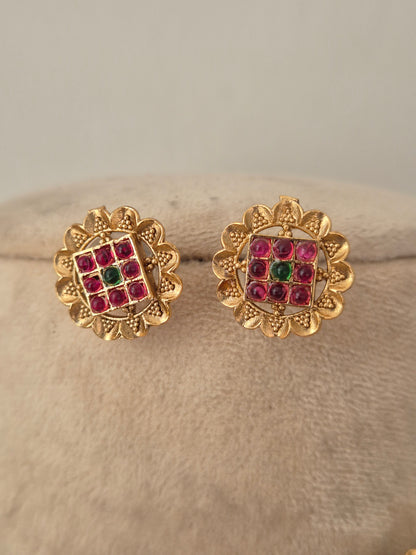 Traditional imitation stud earrings crafted with brass alloy and red-green stone studded round links by naitri.in
