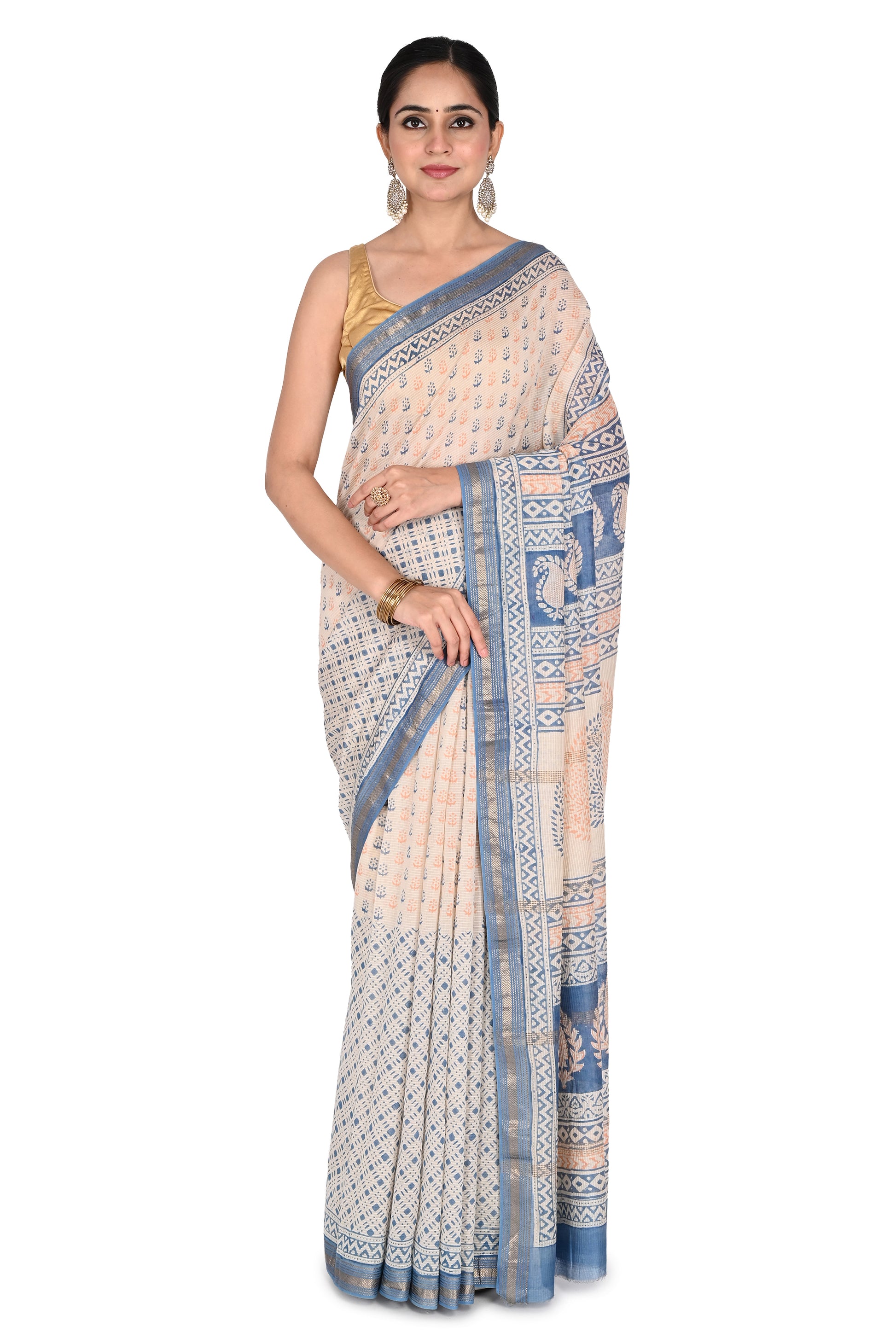 Woman modeling the Kanaka Maheshwari Saree, a beige and white cotton silk saree with intricate blue hand block printed geometric patterns and a gold border by naitri.in