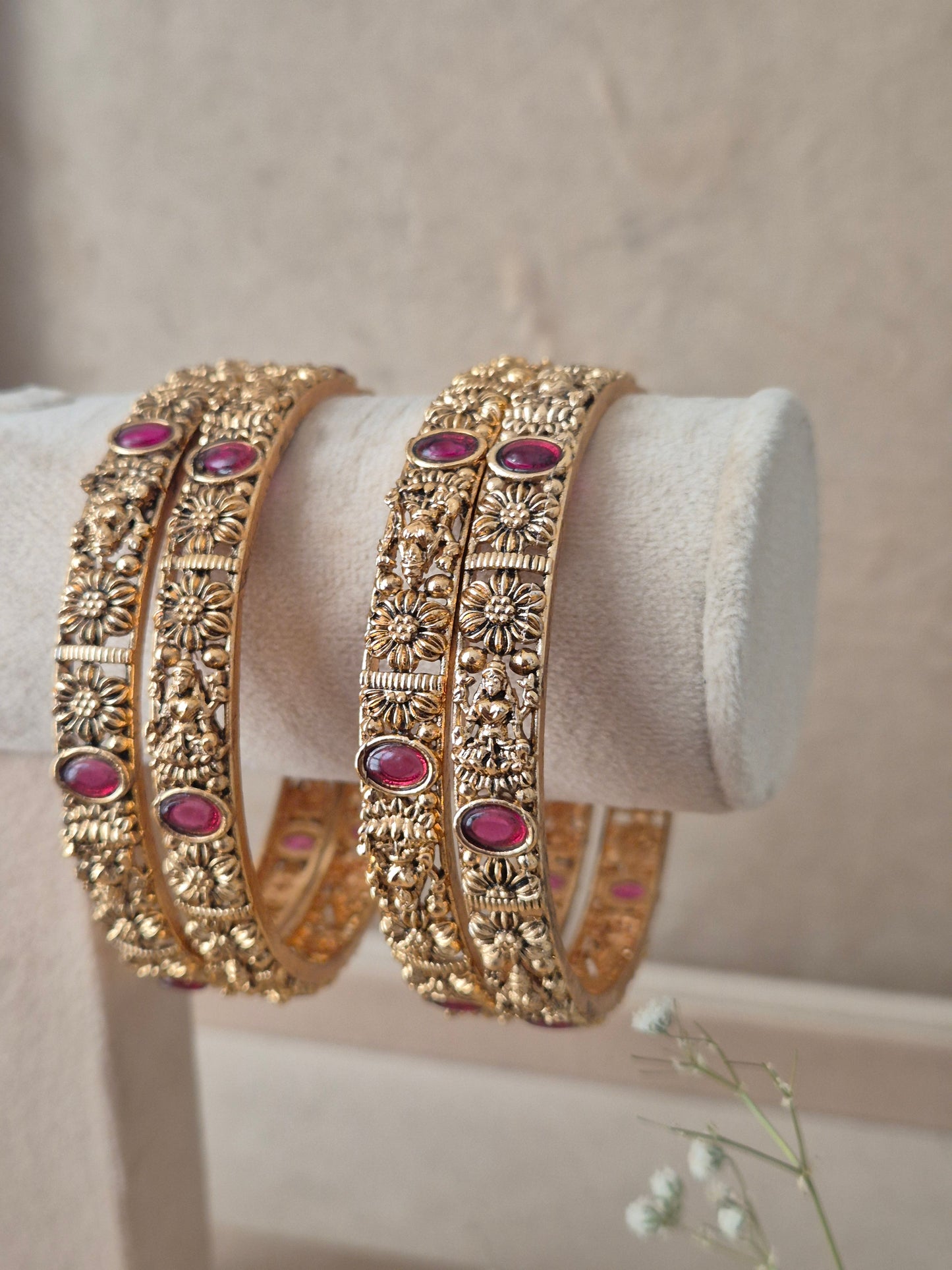 Close-up of Naitri Kashish premium gold ethnic bangle set with traditional Indian metalwork and vibrant red gemstone details. by naitri.in