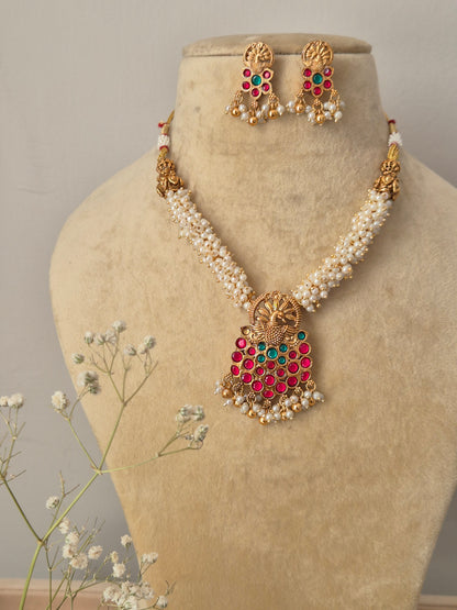 Kaveri Necklace Set: Gold-plated brass temple pendant with colorful stones and white pearl layers from the Naitri Golden Jewellery collection by naitri.in