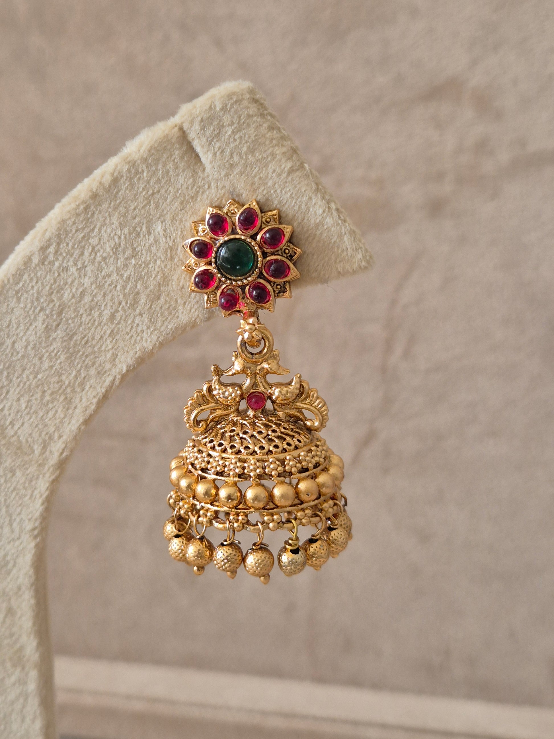 Handcrafted gold Jhumka earrings with red and green stone embellishments by naitri.in