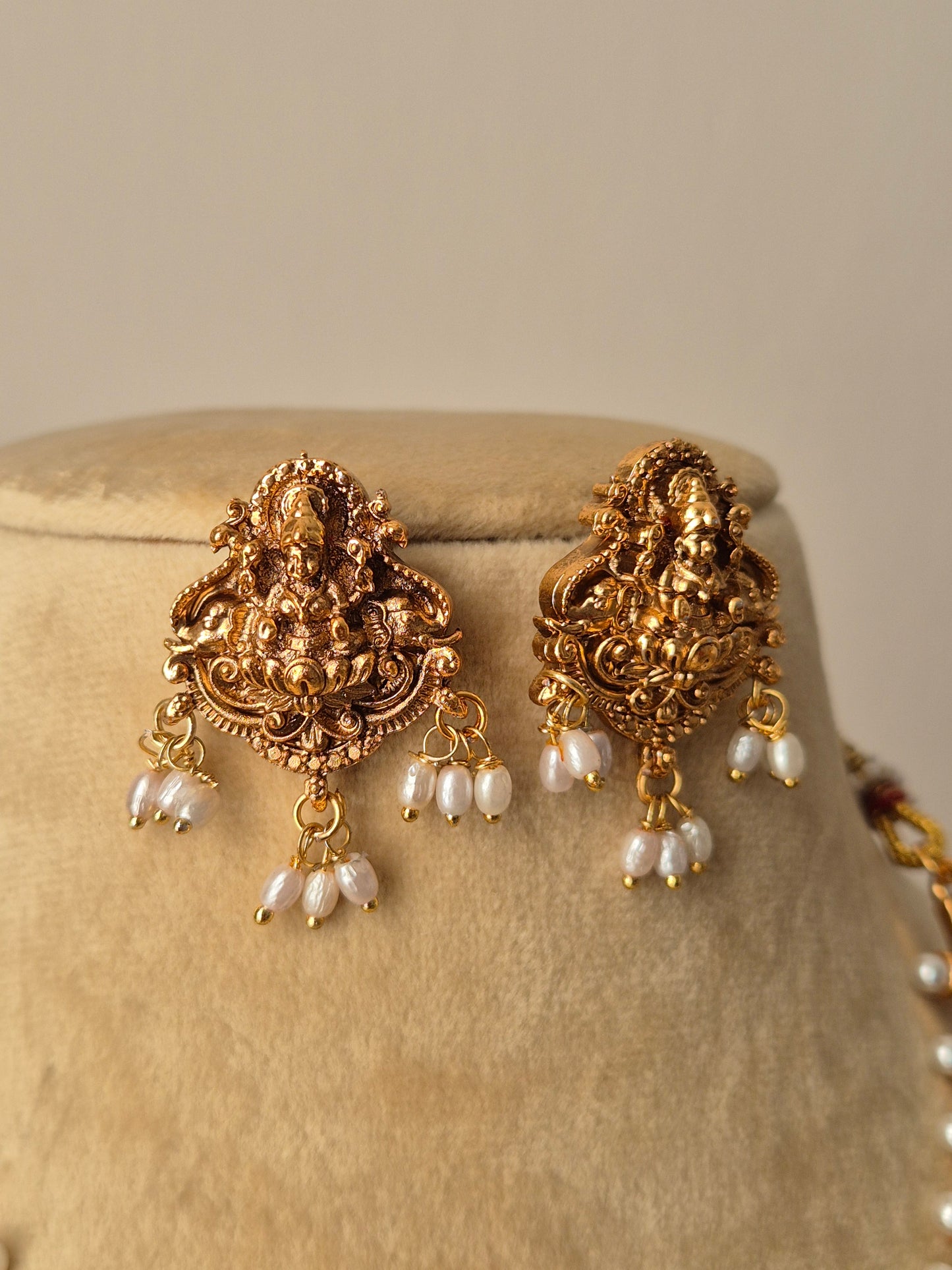 Pair of gold earrings with pearl-like stones temple earring goddess Lakshmi motifs by naitri.in