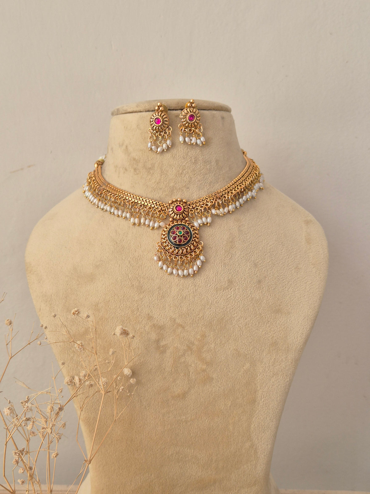 Khushi Necklace Set featuring traditional gold temple motifs with gemstone accents and matching earrings by Naitri.in