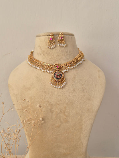 Khushi Necklace Set featuring traditional gold temple motifs with gemstone accents and matching earrings by Naitri.in