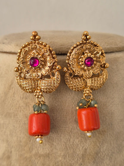 Kishori earrings in antique gold finish featuring intricate motifs, ruby center stones by Naitri