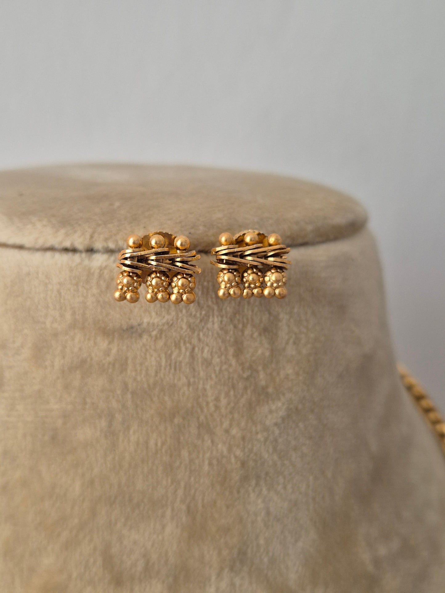 earring with featuring an intricate textured bead pattern along its edges with coordinating round stud earrings by naitri.in